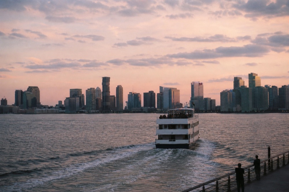 A dinner cruise boat passing the Boston skyline at twilight