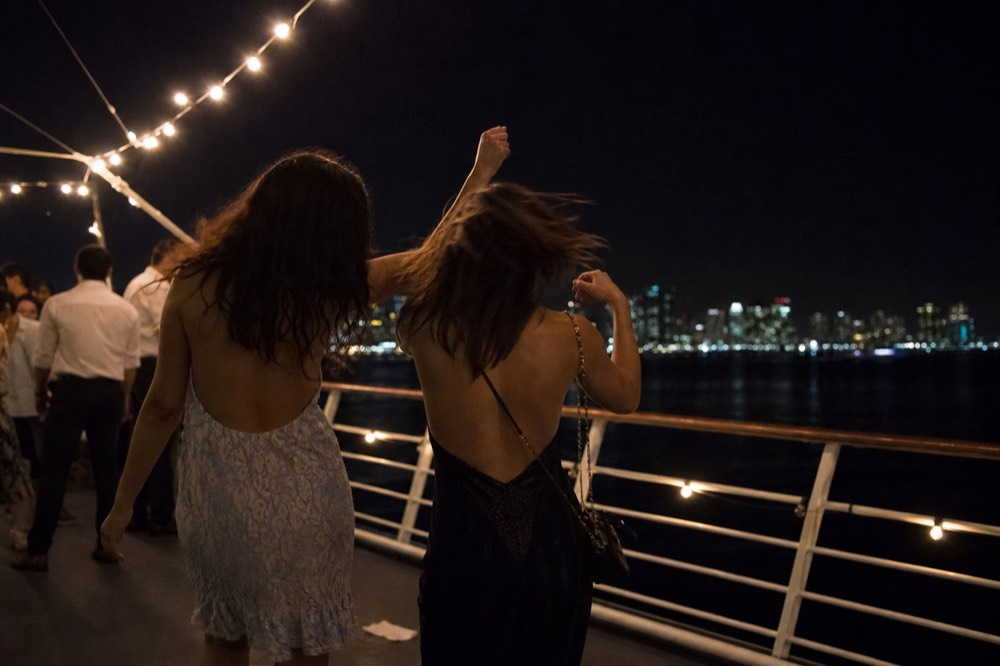 Couple dancing on cruise deck with Boston skyline at night