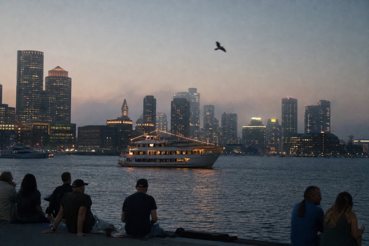 Boston harbor skyline at dusk with cruise ship lights