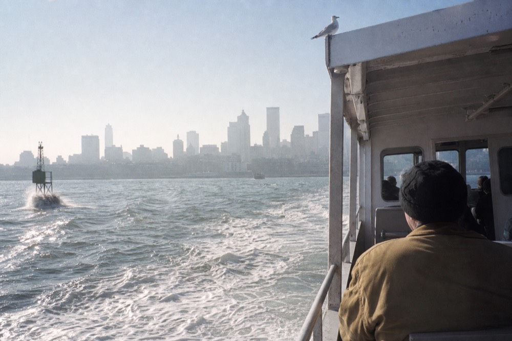 A passenger ferry crossing Boston Harbor with the downtown skyline behind it