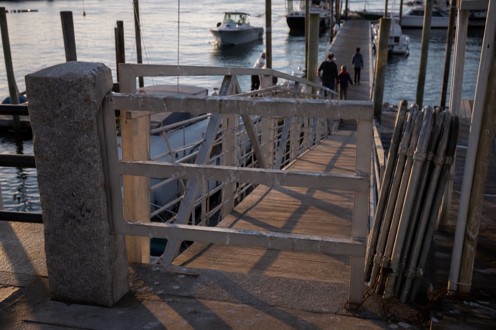 A gangway and boarding area at a Boston pier in late afternoon light