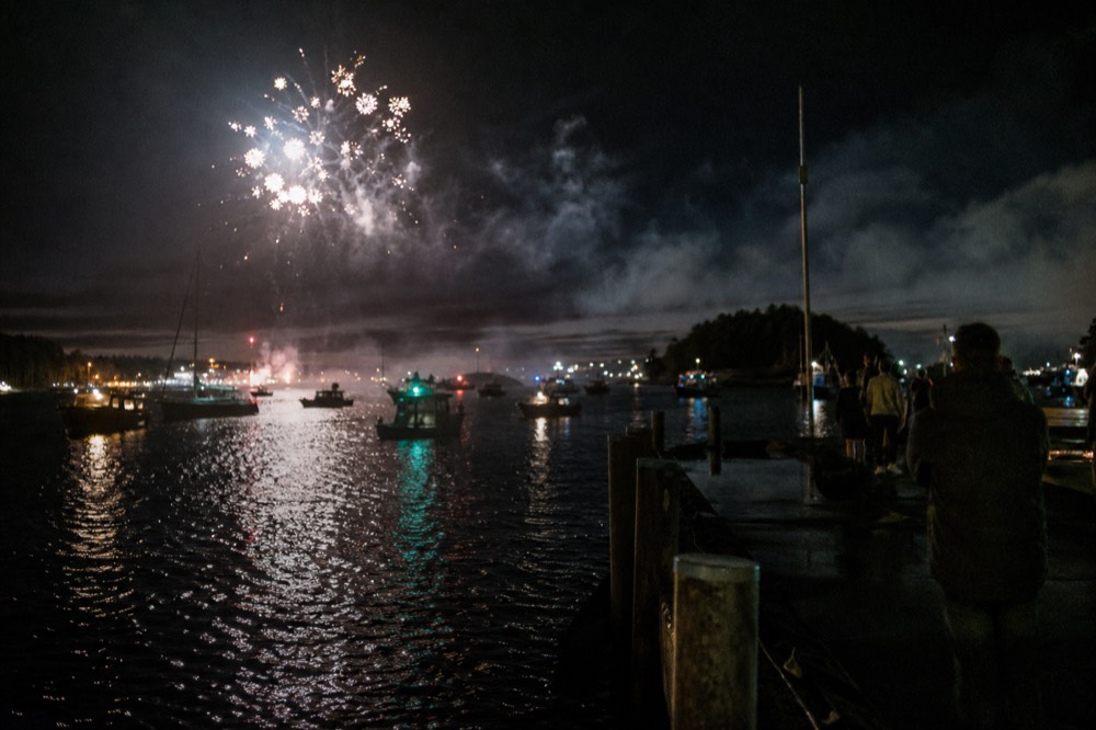 Fireworks bursting over Boston Harbor at night