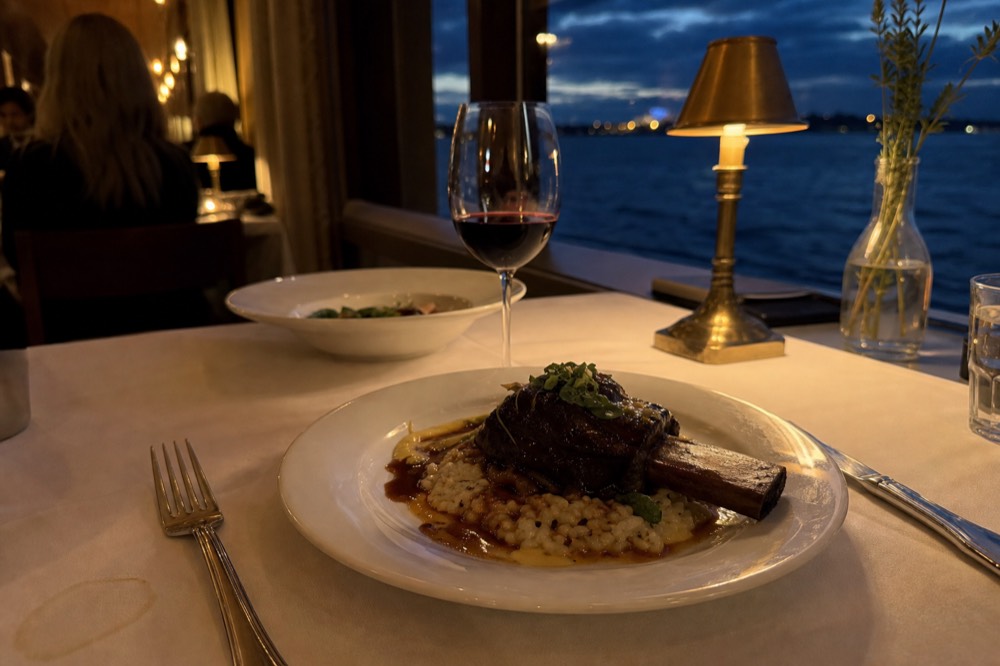 Plated dinner on white tablecloth with harbor view