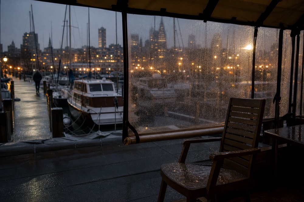 Rainy evening on Boston Harbor with lit skyline